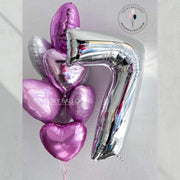 Shiny silver balloon with the number seven on it.