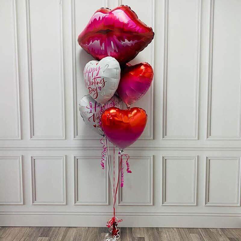 Valentine's Day balloon bouquet with red lips and heart-shaped balloons in red, pink, and white.